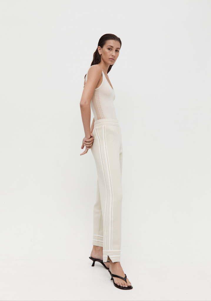 Woman wearing a white dress with thin straps on a white background
