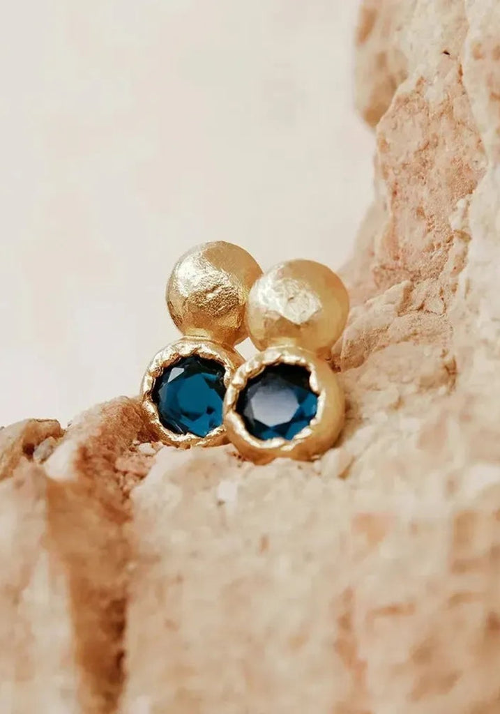 Agapée Petra Earrings resting on a stone