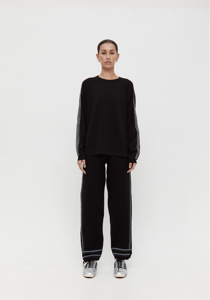 Person wearing a black outfit with white stripes on a white background
