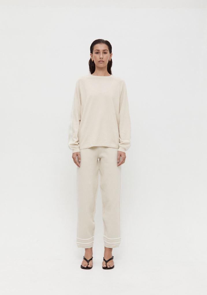 Person wearing a cream-colored outfit on a white background