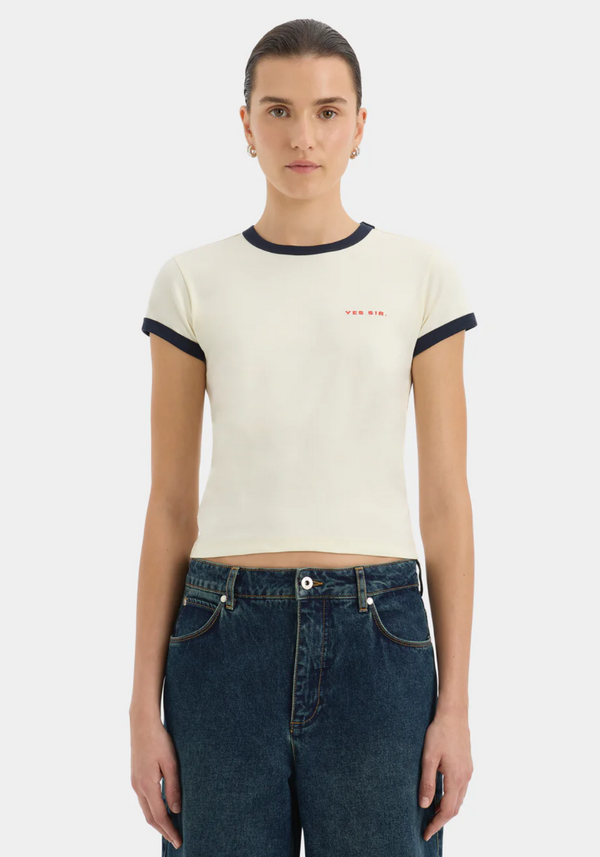 Woman wearing a white t-shirt with black trim and blue jeans on a white background